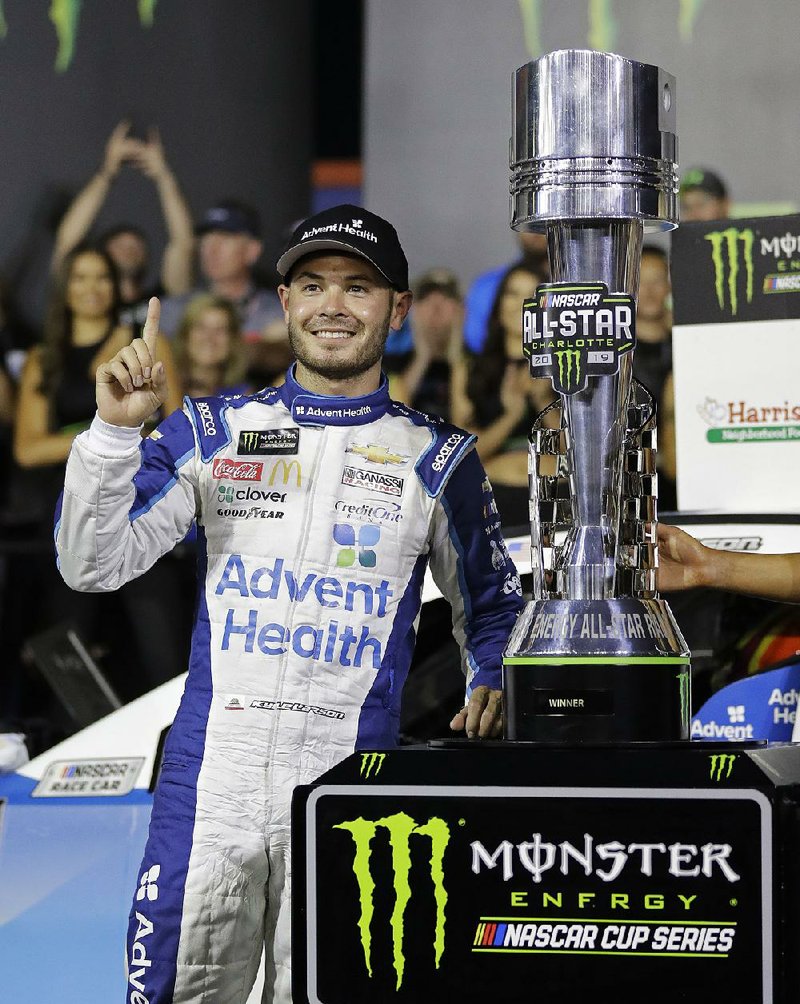 Kyle Larson poses with the trophy after holding off defending champion Kevin Harvick to win the NASCAR All-Star Race on Saturday at Charlotte Motor Speedway in Concord, N.C. 