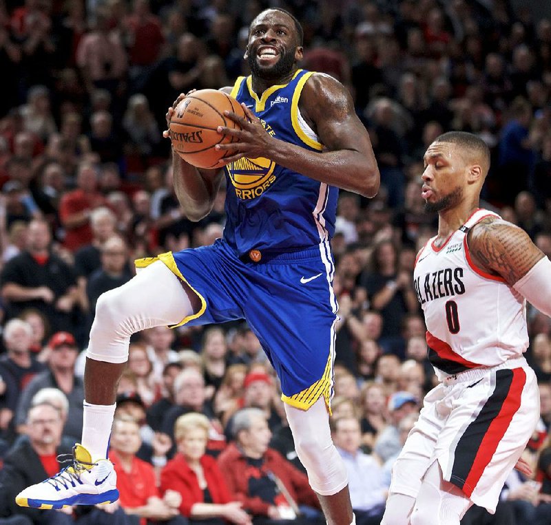 Golden State Warriors forward Draymond Green prepares to shoot over Portland Trail Blazers guard Damian Lillard during the first half of Game 3 of the Western Conference finals Saturday in Portland, Ore. Green had 20 points, 13 rebounds and 12 assists to lead the Warriors to a 110-99 victory for a 3-0 series lead. 