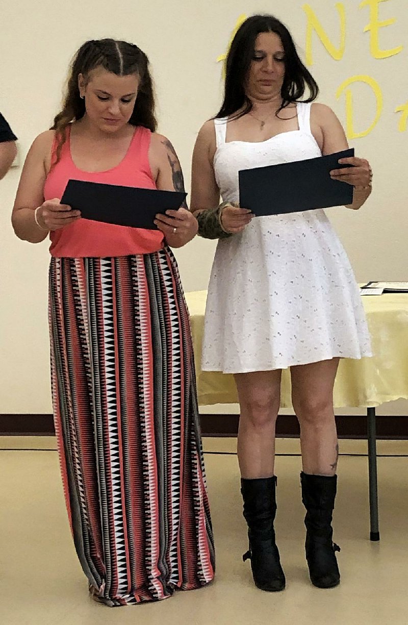 Holly Odom (left) and Tisha Samuels get their diplomas last week for completing nine months of treatment after leaving the 90-day jail program. 