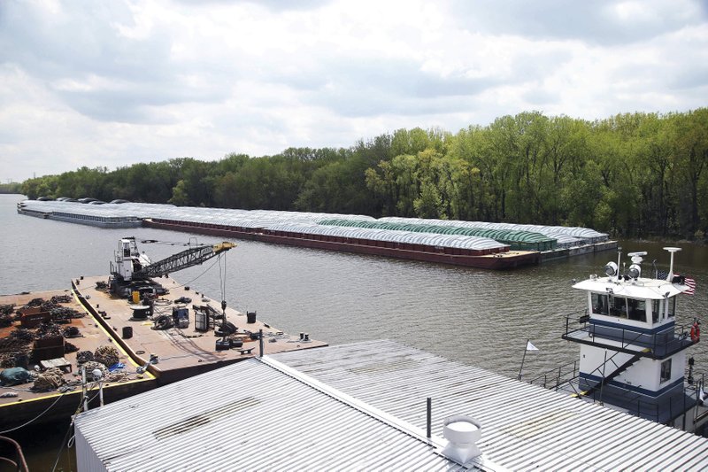 In this Tuesday, May 14, 2019 photo, barges already loaded with soy beans, potash or scrap steel await movement on the Mississippi River in St. Paul, Minn., as spring flooding interrupts shipments on the river. Historic Midwest flooding that began in March has left parts of the Mississippi River closed for business. (AP Photo/Jim Mone)