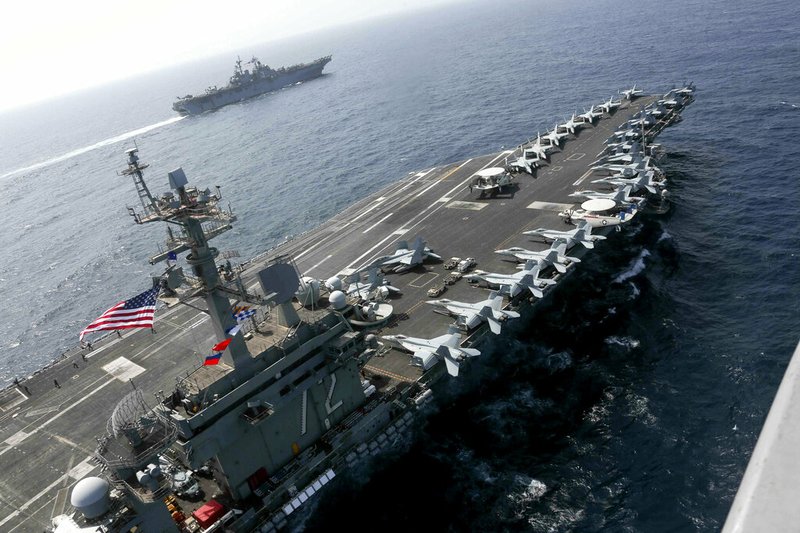 In this Friday, May 17, 2019, photo released by the U.S. Navy, the USS Abraham Lincoln sails in the Arabian Sea near the amphibious assault ship USS Kearsarge. Commercial airliners flying over the Persian Gulf risk being targeted by "miscalculation or misidentification" from the Iranian military amid heightened tensions between the Islamic Republic and the U.S., American diplomats warned Saturday, May 18, 2019, even as both Washington and Tehran say they don't seek war.