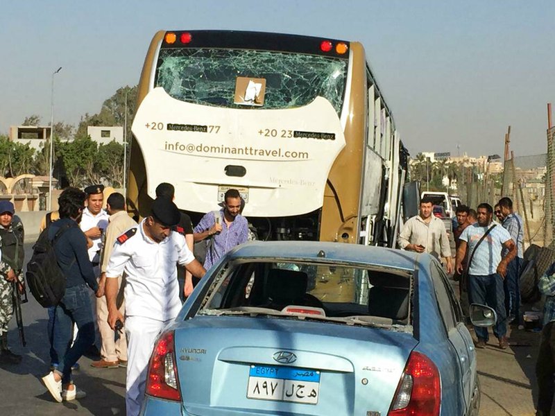 Police inspect a car and a bus that were damaged by a bomb, in Cairo, Egypt, Sunday, March 19, 2019. Egyptian officials say a roadside bomb has hit a tourist bus near the Giza Pyramids. They said Sunday’s blast wounded at least 17 people including tourists. 