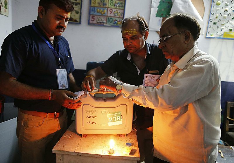 Election officers in Varanasi, India, seal an electronic voting machine Sunday at the end of polling in the final phase of the country’s national elections. 