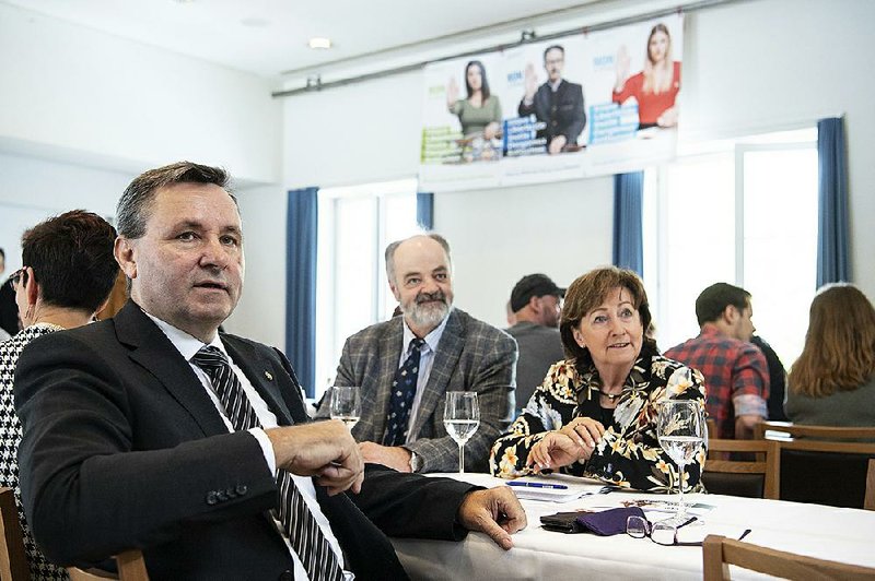 Werner Salzmann (front, left), Swiss parlamentarian of conservative party SVP and a member of the committee against the European Union gun laws and policies, speaks at the committee’s meeting Sunday in Burgdorf, Switzerland. 