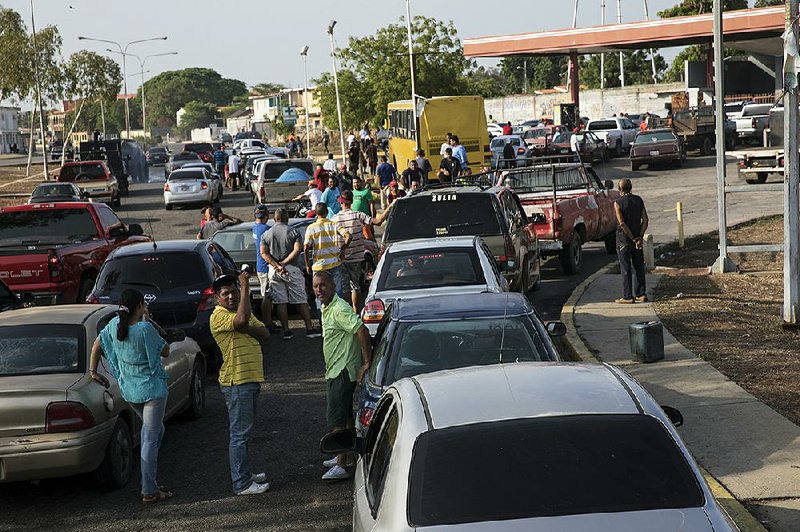 People wait in sometimes mile-long lines to get gasoline last week in Cabimas, Venezuela.