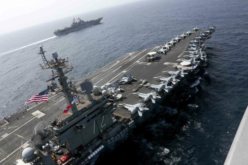 CORRECTS DATE - In this Friday, May 17, 2019, photo released by the U.S. Navy, the USS Abraham Lincoln sails in the Arabian Sea near the amphibious assault ship USS Kearsarge. Commercial airliners flying over the Persian Gulf risk being targeted by &quot;miscalculation or misidentification&quot; from the Iranian military amid heightened tensions between the Islamic Republic and the U.S., American diplomats warned Saturday, May 18, 2019, even as both Washington and Tehran say they don't seek war. (Mass Communication Specialist 1st Class Brian M. Wilbur, U.S. Navy via AP)