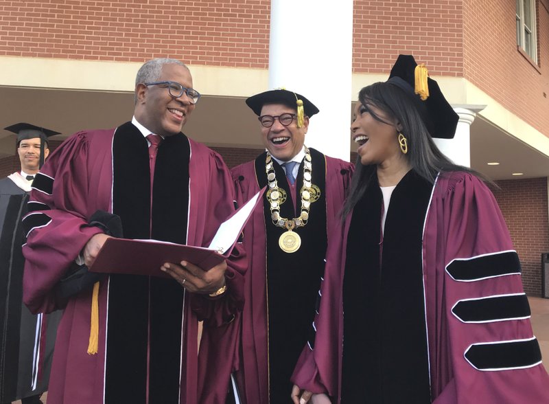 Robert F. Smith, left, laughs with David Thomas, center, and actress Angela Bassett at Morehouse College on Sunday, May 19, 2019, in Atlanta. Smith, a billionaire technology investor and philanthropist, said he will provide grants to wipe out the student debt of the entire graduating class at Morehouse College - an estimated $40 million. Smith, this year's commencement speaker, made the announcement Sunday morning while addressing nearly 400 graduating seniors of the all-male historically black college in Atlanta. (Bo Emerson/Atlanta Journal-Constitution via AP)