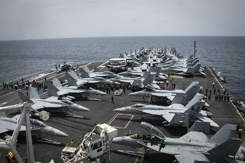 Sailors search for foreign objects and debris on the flight deck of the Nimitz-class aircraft carrier USS Abraham Lincoln in the Arabian Sea on Sunday. 