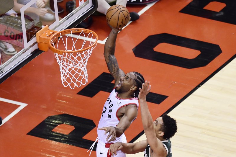 TWO MORE POINTS: Toronto Raptors forward Kawhi Leonard (2) scores past Milwaukee Bucks guard Malcolm Brogdon (13) during the second overtime period of Sunday's NBA Eastern Conference finals in Toronto.