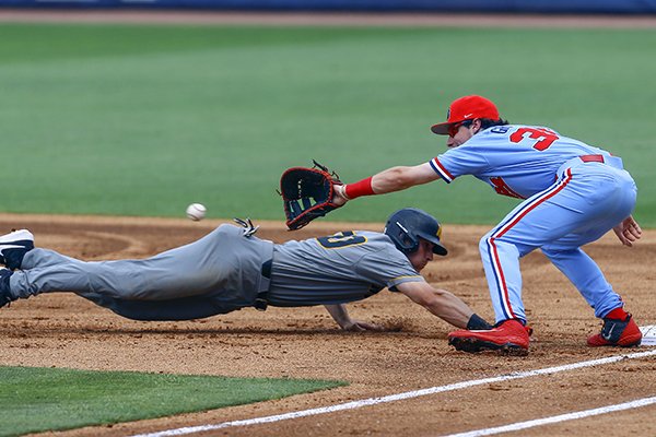 Missouri's Kameron Misner dives back to first base ahead of the throw to Ole Miss first baseman Kevin Graham during the first inning of the Southeastern Conference tournament NCAA college baseball game, Tuesday, May 21, 2019, in Birmingham, Ala. (AP Photo/Butch Dill)

