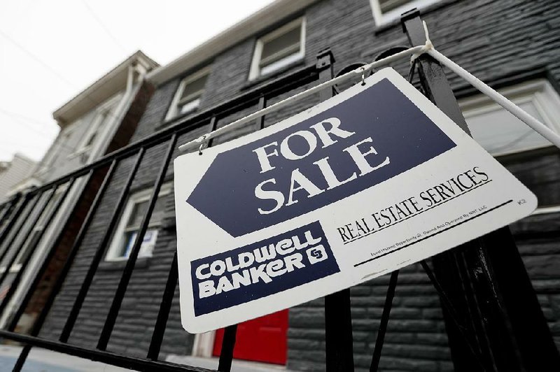 A sign hangs outside a house for sale in Pittsburgh in January. 