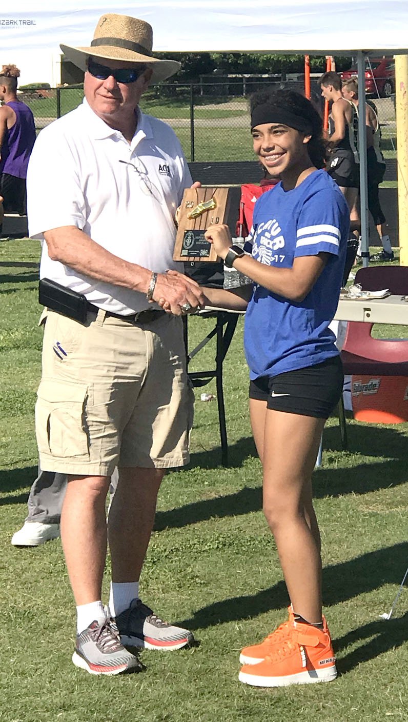 Westside Eagle Observer/SUBMITTED Decatur's Desi Meek (right) receives a trophy for her fifth-place finish in the Arkansas Heptathlon track meet at the Fayetteville Track Complex near Ramey Junior High School in Fayetteville May 16. Meek competed in seven different events, including the 100-meter hurdles in which she took the 2A state championship on April 23.