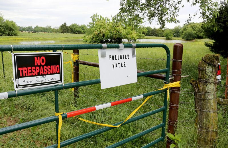 NWA Democrat-Gazette/DAVID GOTTSCHALK Signs on a private gate leading to NWA Steele Farms say the water pond on the land is contaminated. The Steele family says Bethel Heights' treatment plant system is dumping untreated water on the Steele Farms property.