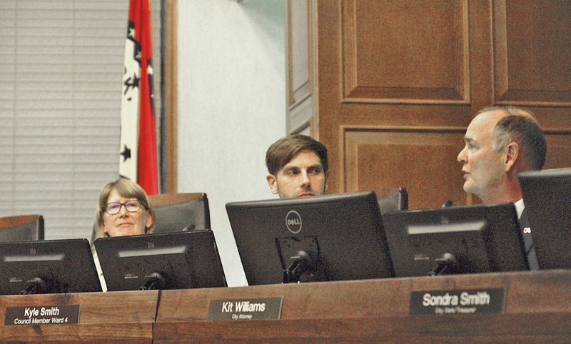 NWA Democrat-Gazette/STACY RYBURN Teresa Turk (from left) and Kyle Smith, both Fayetteville City Council members, look on as Kit Williams, city attorney, speaks Tuesday during a council meeting at City Hall. The council passed an ordinance prohibiting the city from buying expanded polystyrene foam products.