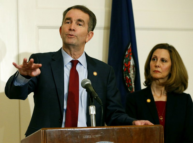 FILE - In this Feb. 2, 2019 file photo, Virginia Gov. Ralph Northam, left, gestures as his wife, Pam, listens during a news conference in the Governors Mansion at the Capitol in Richmond, Va. (AP Photo/Steve Helber, File)