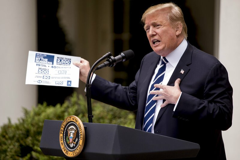 President Donald Trump holds up a stat sheet having to do with the Mueller Report as he speaks in the Rose Garden at the White House in Washington, Wednesday, May 22, 2019.(AP Photo/Andrew Harnik)