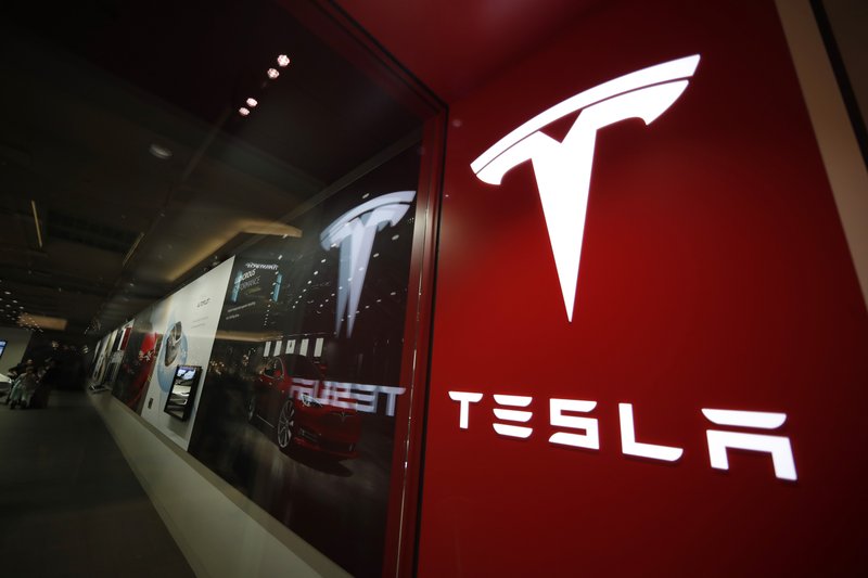 In this Feb. 9, 2019 file photo, a sign bearing the company logo is displayed outside a Tesla store in Cherry Creek Mall in Denver. (AP Photo/David Zalubowski, File)
