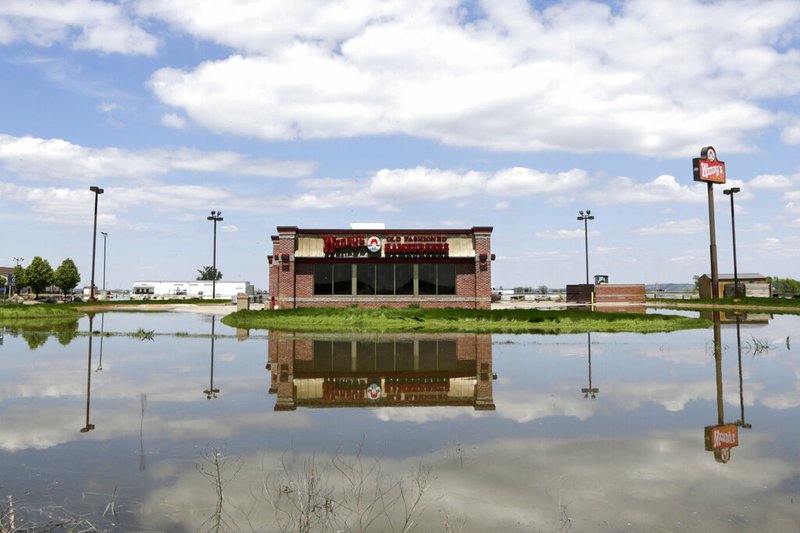 A Wendy's store in Percival, Iowa, is reflected in floodwaters from the Missouri River, Friday, May 10, 2019. The House on Friday passed a $19 billion disaster aid bill that would deliver long-sought relief to farmers, victims of hurricanes and floods, and rebuild southern military bases, as Democrats try to dislodge the legislation from a Senate logjam over aid to hurricane-slammed Puerto Rico. (AP Photo/Nati Harnik)