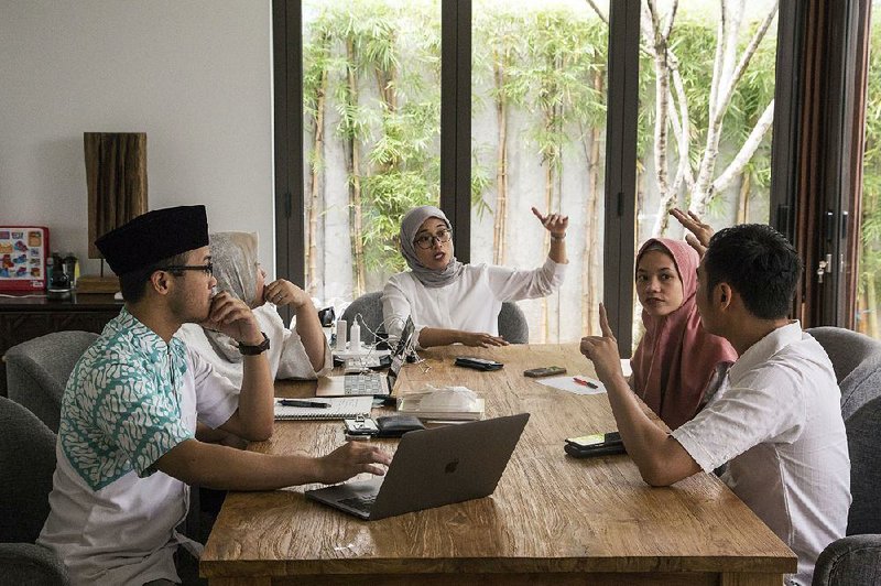 Archie Fitrah Wirija (left), founder and executive producer of the Quran Indonesia Project, meets with other members of the group in Jakarta, Indonesia. The project, which started with celebrities reading verses from the holy book, has moved on to include videos of sign language translations. 