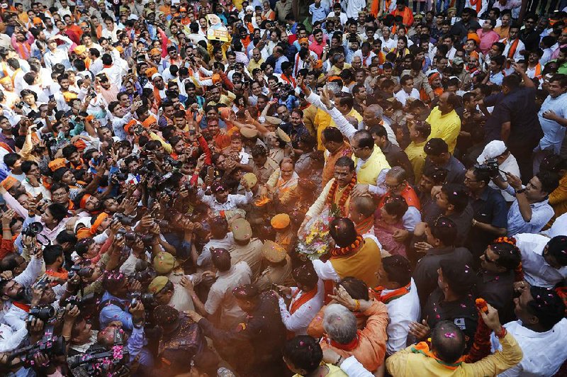 Backers of India’s ruling Bharatiya Janata Party swarm Yogi Adityanath, chief minister of Uttar Pradesh state, as they celebrate their party’s apparent victory in Lucknow, India. 