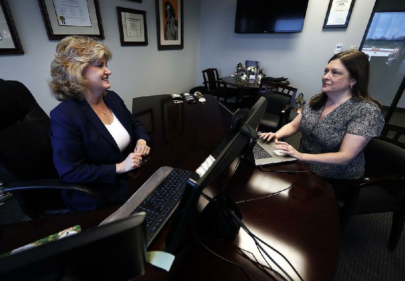 Meloney Perry (left), owner of Perry Law, talks with a member of her staff, attorney Karla Roush, at the firm in Dallas. “I learned the ‘old school’ way, but it’s changed,” Perry said. 