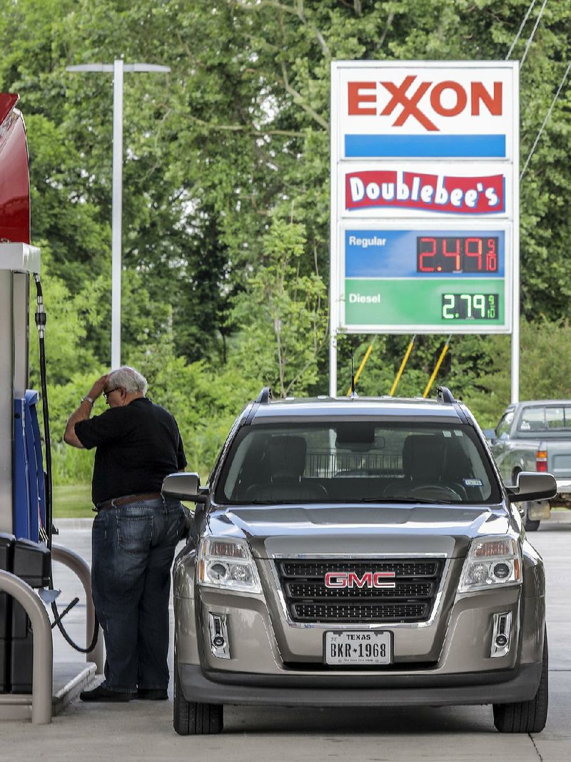 A man fills up his tank at a gas station on Cantrell Road in Little Rock on Thursday afternoon. Gas prices will not have much of an impact on Memorial Day travel, AAA predicts. 