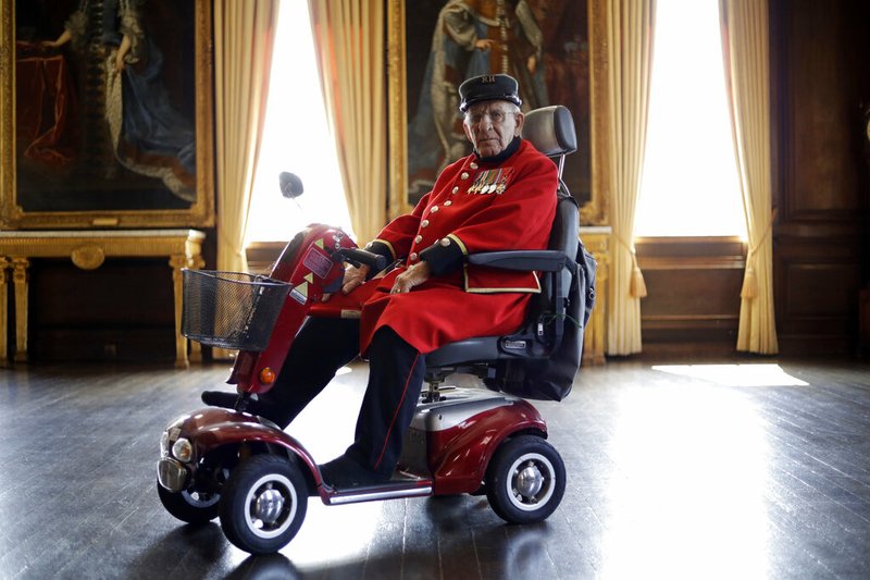 British Chelsea Pensioner and D-Day veteran Frank Mouque poses for a portrait during a D-Day 75th anniversary event in the State Apartments at the Royal Hospital Chelsea in London, May 13, 2019. Mouque, who can't hear well now and answered media questions by reading them from a piece of paper, was a Sapper and Corporal in the British Royal Engineers. On D-Day he landed on Sword beach and carried with him 21 pounds of explosives to blow down telegraph poles. (AP Photo/Matt Dunham)