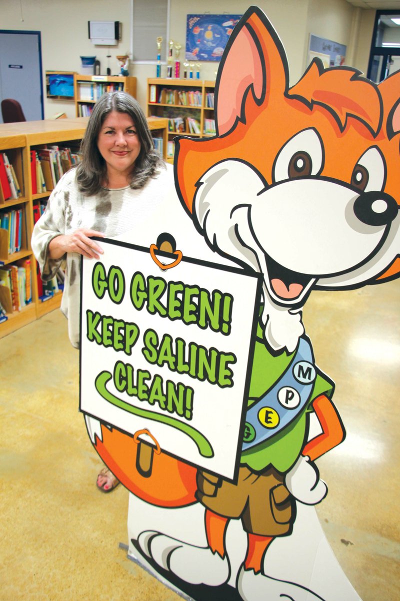 Judi Copley, the media specialist at Davis Elementary School in Alexander, stands behind Smarty, the mascot for Recycle Saline. Copley was recently named the 2019 YEA! Team Leader of the Year.