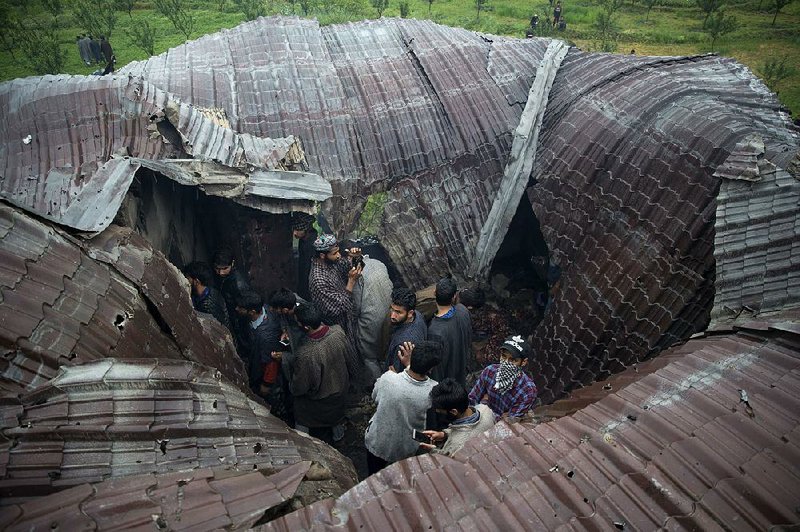 Villagers look through a house destroyed in a raid Friday in Tral, south of Srinigar in India-controlled Kashmir. 