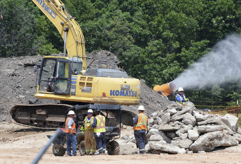 NWA Democrat-Gazette/CHARLIE KAIJO A crew works Friday excavating the stump dump fire site in Bella Vista.