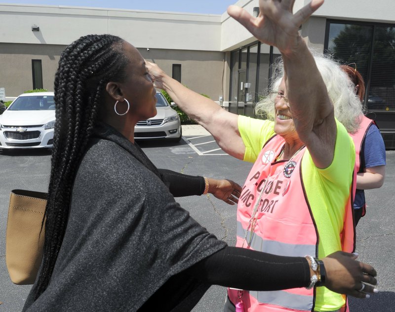 In this May 17, 2019 file photo, Dr. Yashica Robinson, is greeted with a hug from Josie Poland, a clinic escort, while arriving for work at the Alabama Women's Wellness Center in Huntsville, Ala. Abortion providers are asking a federal judge to block an Alabama law that would ban most abortions in the state. The American Civil Liberties Union and Planned Parenthood filed the lawsuit Friday, May 24 on behalf of Alabama abortion providers seeking to overturn the nation's most stringent abortion law. The plaintiffs in the case are the three Alabama clinics that perform abortions, Planned Parenthood and Robinson, an obstetrician who also provides abortions at the Huntsville clinic. (AP Photo/Eric Schultz, File)