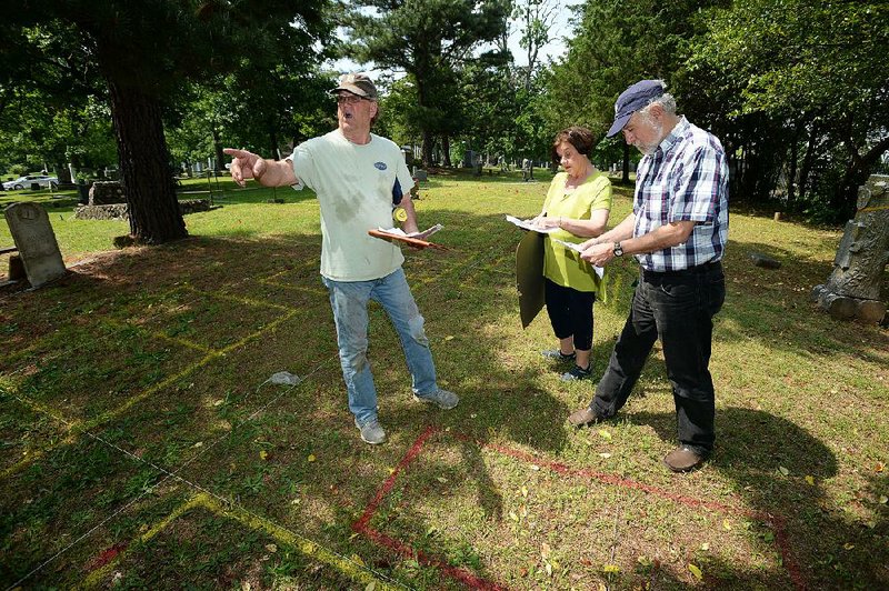 Bob Young (left), administrator of the Fayetteville Evergreen Cemetery Association, speaks Wednesday with Marilyn Heifner, association president, and Ken Kvamme, a professor of anthropology at the University of Arkansas, Fayetteville, while working to locate unmarked graves in the cemetery. 