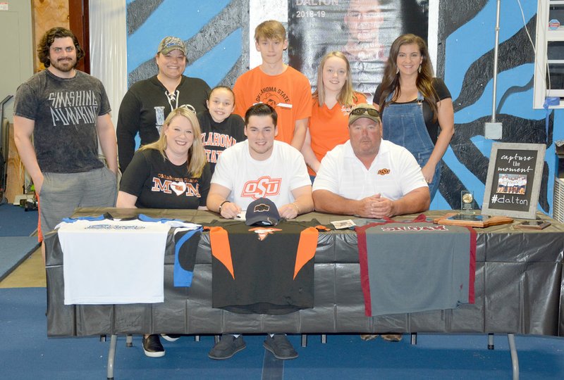 Graham Thomas/Siloam Sunday Siloam Springs senior Dalton Ferguson signed a letter of intent Tuesday, May 21, to join the cheerleading team at Oklahoma State University. Pictured are: front from left, mother Misty Ferguson, Dalton Ferguson, father Derek Ferguson; back from left, James Dunham, Elite Cheer coach Elicia Williamson, sister Mavery Ferguson, brother Dillon Ferguson, sister Macie Ferguson and Siloam Springs cheer coach Jackie Clement.