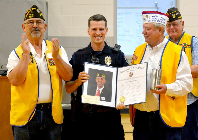 Janelle Jessen/Siloam Sunday School resource officer Joshua Fritz, center, was surprised with the Veterans of Foreign Wars National Law Enforcement Award during an assembly at the intermediate school on Wednesday. The award was presented by Michael Butler, left, quartermaster for VFW Post 1674, and Frank Lee, Post 1674 commander.