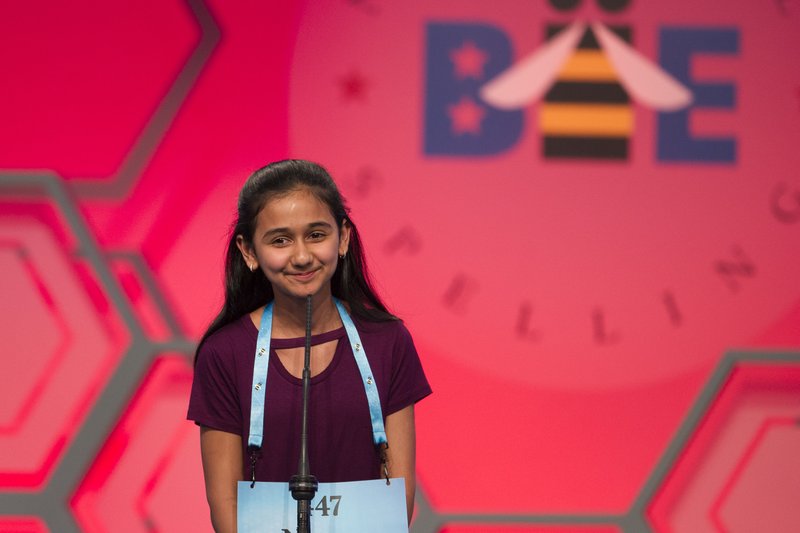 FILE - In this May 31, 2018 file photo, Naysa Modi, 12, from Frisco, Texas, spells her word incorrectly during the evening finals of the Scripps National Spelling Bee in Oxon Hill, Md. An unremarkable sound can be the toughest thing for spellers to master at the Scripps National Spelling Bee. It's known as the schwa. It sounds like "Uh," and any vowel can make the sound.  Spellers have a variety of techniques to figure out unfamiliar schwas, but none of the strategies is foolproof, and sometimes the only things to do are to memorize the word or guess. (AP Photo/Cliff Owen)