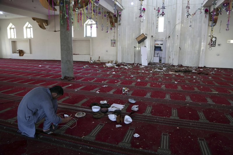 An Afghan Journalist take a photo inside a mosque after a bomb explosion during Friday prayer on the outskirts of Kabul, Afghanistan, Friday, May 24, 2019. According to Kabul police chief's spokesman, Basir Mujahid, the bomb was concealed in the microphone used to deliver the sermon. The prayer leader, Maulvi Samiullah Rayan, was the intended target, the spokesman added. (AP Photo/Rahmat Gul)