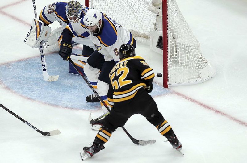 Boston’s Sean Kuraly scores the go-ahead goal past St. Louis’ Joel Edmundson (right) and goalie Jordan Binnington during the third period in Game 1 of the Stanley Cup Final on Monday in Boston. The Bruins won 4-2.