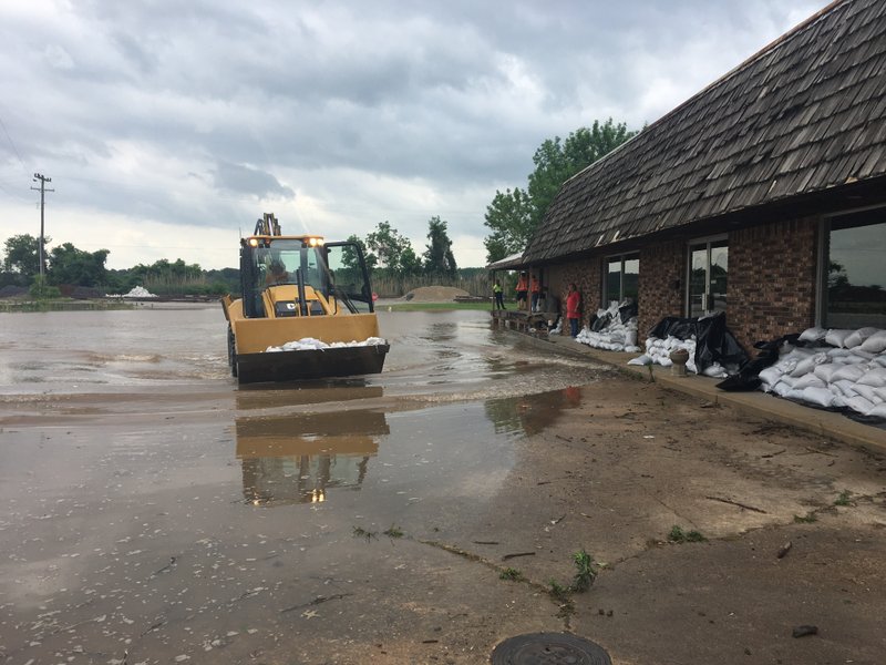 Crews in Ozark work to place sandbags as water rises in the city.