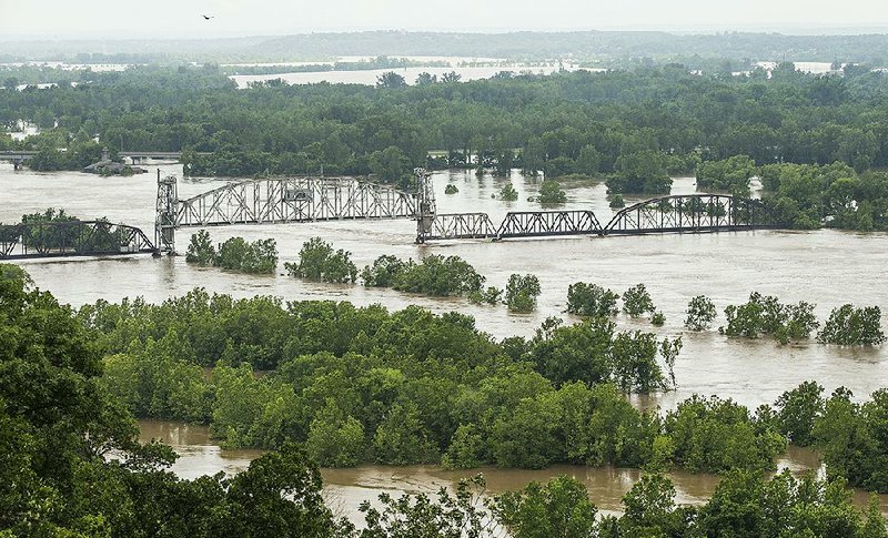 The Arkansas River encroaches on a bridge at Van Buren on Tuesday as seen from a residence on Steward Street in Van Buren. The river is flowing higher and faster than ever before, making it difficult to predict exactly how high it will get, Michael Biggs of the U.S. Army Corps of Engineers said Tuesday. More photos are available at arkansasonline.com/529flooding/ 