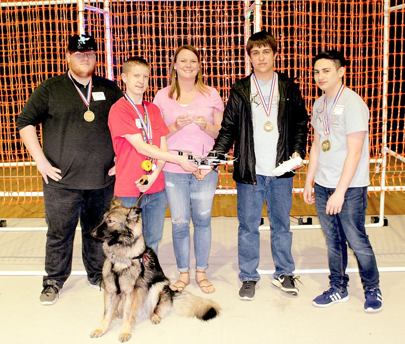 Photo submitted Siloam Springs High School's drone team won first place in 3D-printed presentation, first place in 3D-printed obstacle course and earned the overall award for completing the obstacle course in the least amount of time at University of Arkansas Fort Smith's Drone Day on May 4. Pictured, from left, are team members senior Max Ketcher, sophomore Jackson Fine, teacher Megan Dennison, senior Johnathan Craddock, junior Brandon Dolanski, and Fine's service dog Jasmine.