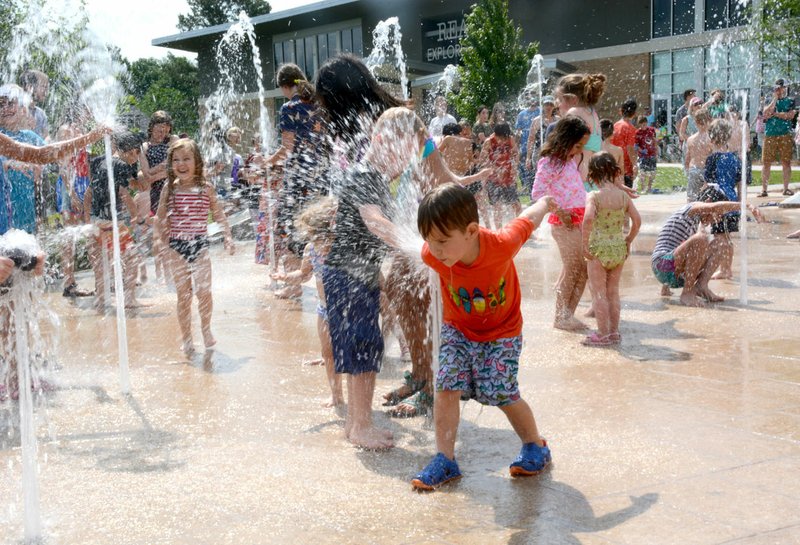 Janelle Jessen/Herald-Leader Children laughed as they played as soon as the fountains in the splash pad were turned on.
