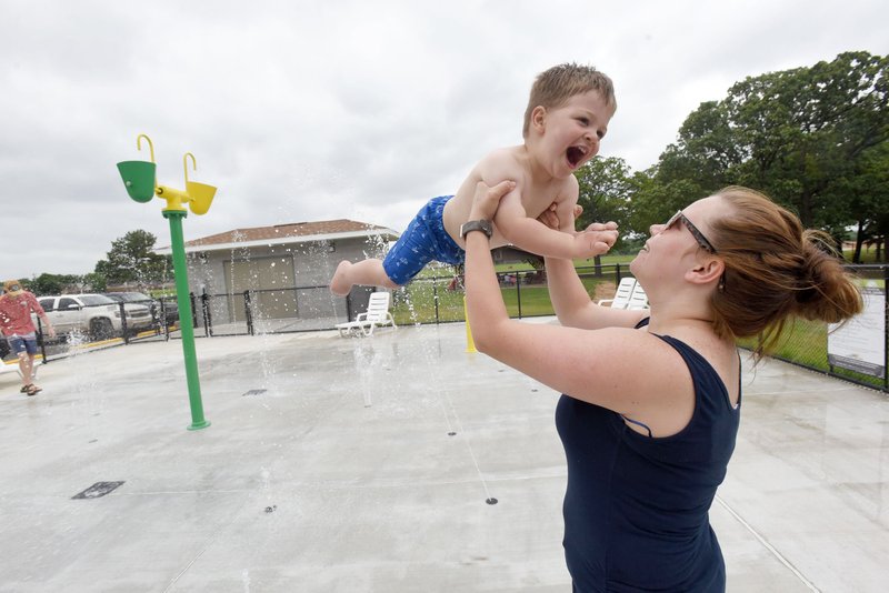 Sara Kirby of Pea Ridge plays Tuesday with her son, Kolt, 2, at the new splash pad at Pea Ridge City Park north of Pea Ridge High School. The splash pad is open daily from 9 a.m. to dark. NWA Democrat-Gazette/FLIP PUTTHOFF