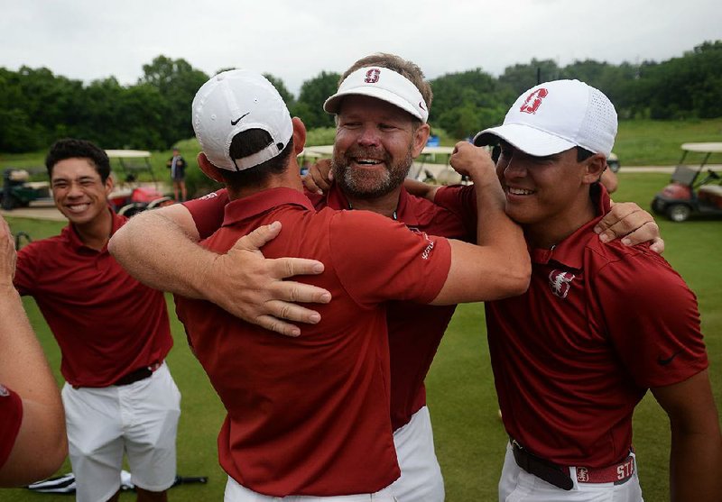 Stanford Coach Conrad Ray (center) hugs players Isaiah Salinda (right) and Brandon Wu after the Cardinal completed a 3-2 victory over Texas to win the national championship Wednesday at Blessings Golf Club in Fayetteville. 