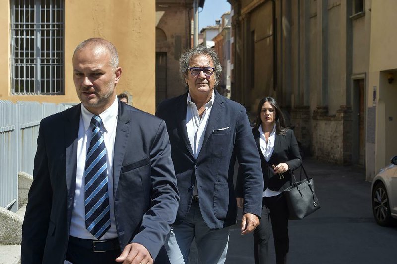 Dr. Guido Fanelli (center) arrives at court in Parma, Italy, earlier this month to answer magistrates’ charges that he took kickbacks  from pharmaceutical executives to help push opioid drugs in Italy. 