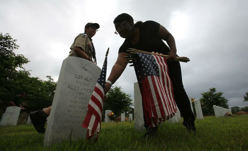 Arkansas Democrat-Gazette/THOMAS METTHE -- 5/29/2019 --
Collecting flags set out for the Memorial Day holiday on Wednesday, May 29, 2019, at the Arkansas State Veterans Cemetery North Little Rock. 