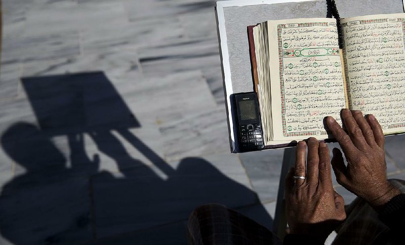 In this file photo, a Palestinian reads verses of the Koran, Islam’s holy book, during the month of Ramadan at Al Emari Mosque in Gaza City. 