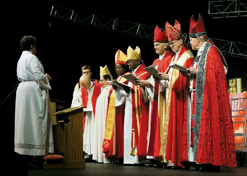 The Rt. Rev. Phoebe Roaf (left) answers questions during the ceremony consecrating her as bishop of the West Tennessee Episcopal Diocese, opposite (from second left) the Rev. Sandy Webb, a member of the diocese’s transition committee from Church of the Holy Communion in Memphis; the Rt. Rev. Herbert Donovan, bishop of the Arkansas diocese from 1981-93; the Rt. Rev. Chilton Knudsen, assisting bishop of Washington; the Rt. Rev. Jennifer Baskerville-Burroughs, bishop of Indianapolis; Presiding Bishop, the Most. Rev. Michael Curry; Roaf’s predecessor, the Rt. Rev. Don Johnson; the Rt. Rev. Shannon Johnston, former bishop of Virginia; and the Rt. Rev. Charles Jenkins III, former bishop of Louisiana. 