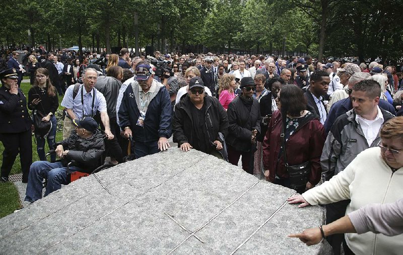 During a dedication ceremony Thursday, people gather around stones that are part of a new memorial glade at ground zero in New York City. 