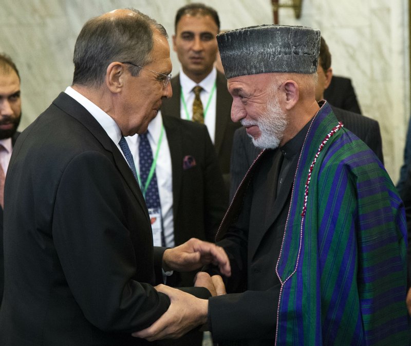 Russian Foreign Minister Sergey Lavrov, left, and former Afghan President Hamid Karzai greet each other prior to their meeting in Moscow, Russia, Tuesday, May 28, 2019. Mullah Abdul Ghani Baradar, the Taliban group's top political leader, and a delegation of Taliban are in Moscow where they are scheduled to meet other Afghans including former President Hamid Karzai and some of the candidates in the presidential elections. (AP Photo/Alexander Zemlianichenko)