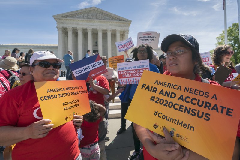 FILE - In this April 23, 2019 file photo, immigration activists rally outside the Supreme Court as the justices hear arguments over the Trump administration's plan to ask about citizenship on the 2020 census, in Washington. A new court filing Thursday, May 30 by lawyers opposing adding the citizenship question to the 2020 census alleges a longtime Republican redistricting expert played a key role in making the change. (AP Photo/J. Scott Applewhite, File)